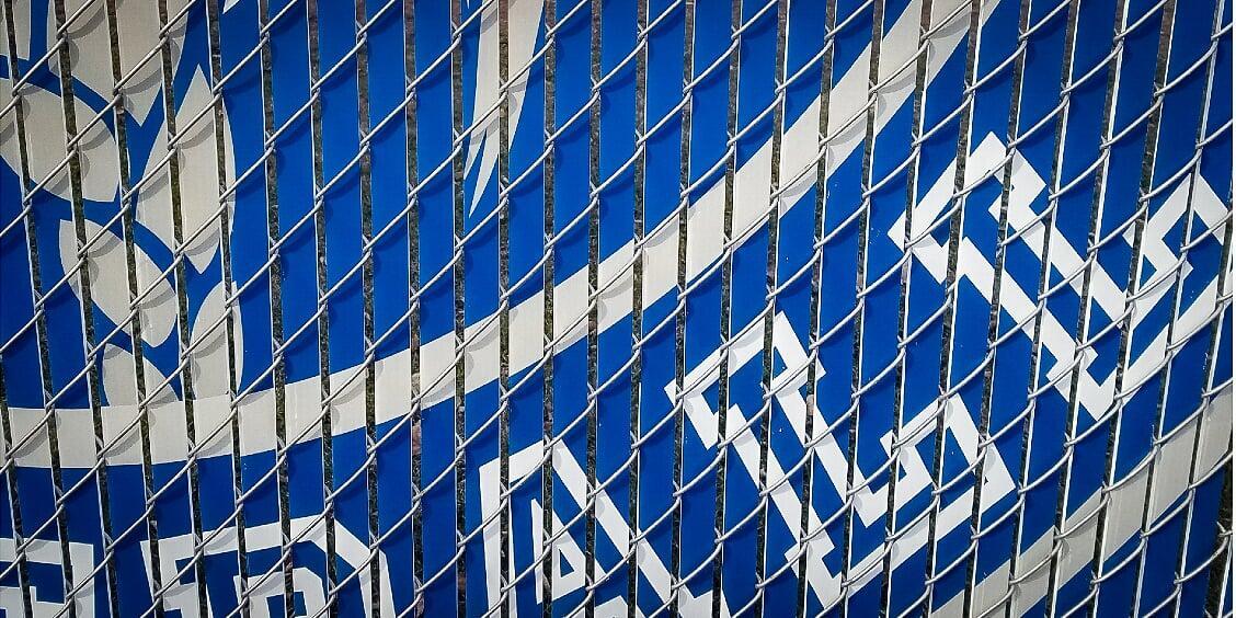 Close up example of custom printed fence slats installed on chain link fence